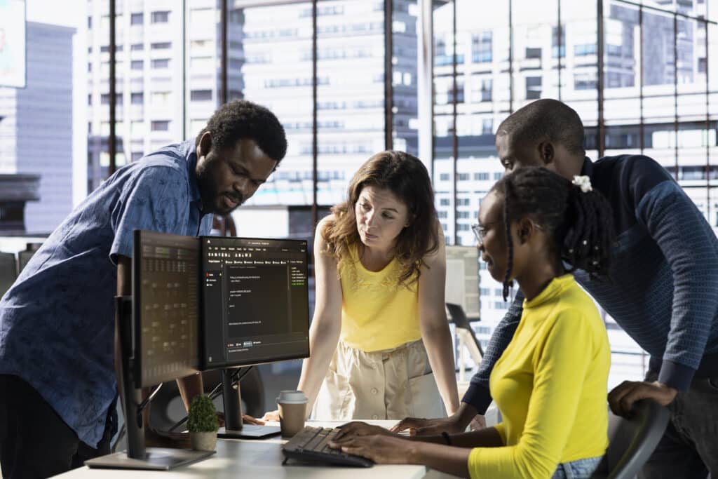 Image of IT specialists working with colleagues.